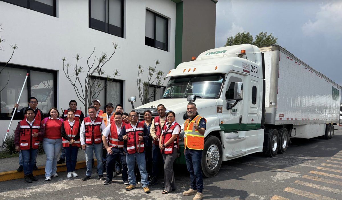 Equipo de Transportes TIUSA junto a un tractocamión